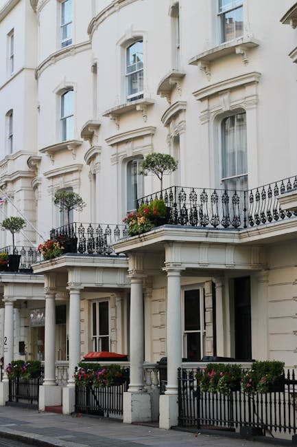 The image depicts a row of elegant Victorian-style terraced townhouses on Marylebone High Street, featuring cream-colored facades with decorative moldings and large sash windows. Each residence has sm